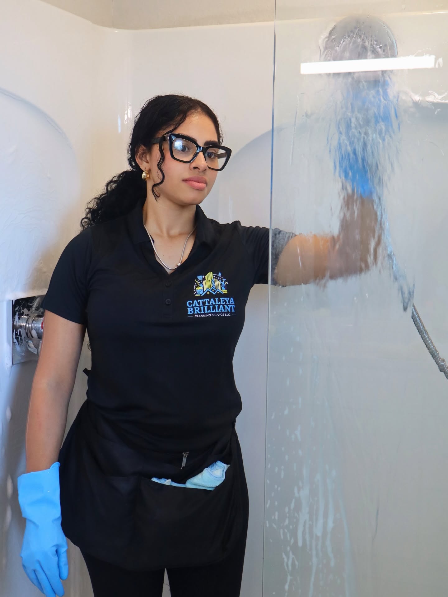 Cattaleya Brilliant team member in the branded uniform detailing a glass shower